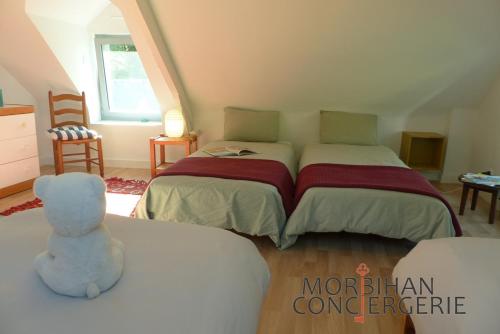 a bedroom with two beds and a blue teddy bear at Belle longère en campagne à Larmor Baden in Larmor-Baden