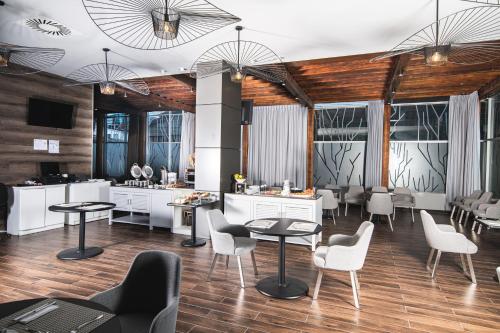 a salon with tables and chairs and windows at Hotel Rennova in La Paz