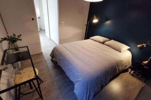 ein Schlafzimmer mit einem großen Bett und einem Glastisch in der Unterkunft Appartement F2 COSY proche de l'HYPER CENTRE in Caen