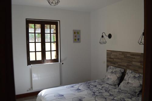 une chambre avec un lit et une fenêtre dans l'établissement Les mansardes Le gîte, à Sarlat-la-Canéda