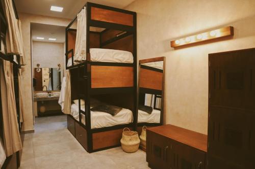 a room with two bunk beds with a mirror at Hostal Barrio Vivo in Mérida