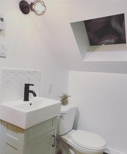a white bathroom with a sink and a toilet at Chalet Rustique CRDS Tremblant in Lac-Superieur