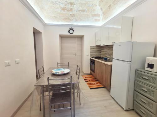 een keuken met een tafel en stoelen en een koelkast bij Casa Vacanze Francesco in Marsala