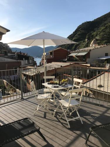 a patio with a table and chairs and an umbrella at Carattino in Vernazza