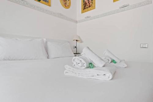 ein Schlafzimmer mit einem weißen Bett und Handtüchern darauf in der Unterkunft HostMe flat Metro Spagna in Rom
