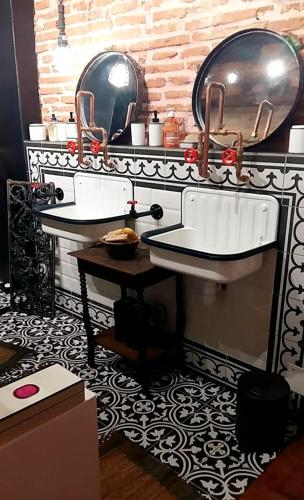 une salle de bain avec deux lavabos et un miroir dans l'établissement la fermette des grains dorés, à Lafrançaise