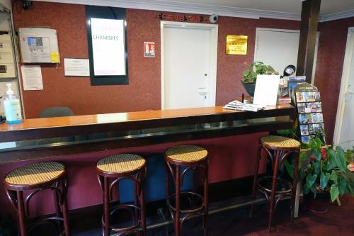 a bar with stools in a restaurant at Fasthotel Bordeaux Eysines in Eysines
