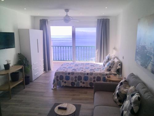 a bedroom with a bed and a view of the ocean at Look and listen to the ocean like never before in Puerto de Santiago