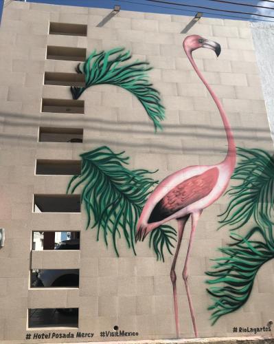 a pink flamingo painted on the side of a building at Hotel Posada Mercy in Río Lagartos
