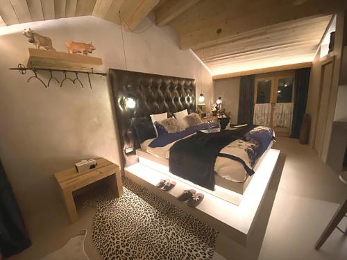a bedroom with a large bed with a black headboard at Micro-lodge, Jardin Secret in Montriond