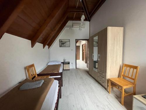 a room with two beds and a chair in it at Tulipán Vendégház in Miskolc