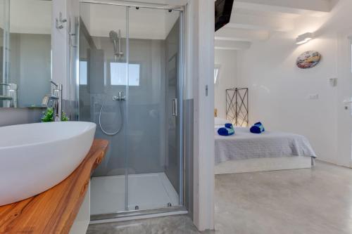 y baño con ducha, bañera y lavamanos. en Anchor House, en Torre Mozza