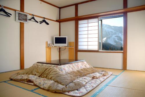 1 dormitorio con 1 cama en una habitación con ventana en Family House Akashiya, en Yuzawa