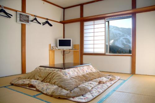 a bedroom with a bed in a room with a window at Family House Akashiya in Yuzawa