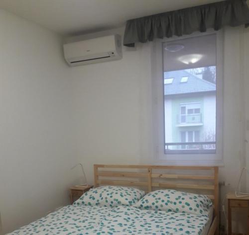 a bedroom with a bed in front of a window at Max Thermal Apartman in Hévíz