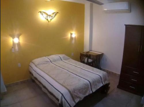 a bedroom with a bed with a butterfly on the wall at Aguacate Suites in Mazatlán