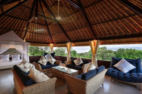 een grote woonkamer met banken en een tafel bij Villa Bukit Nusa Lembongan in Nusa Lembongan