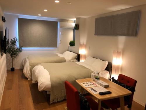 a hotel room with two beds and a table at Time - Vacation STAY 18884v in Kagoshima