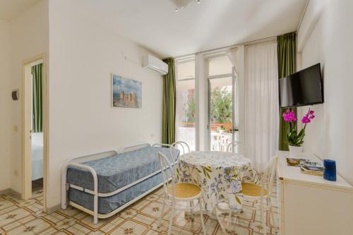 una camera con letto, tavolo e sedie di Oltremare Appartamenti a Principina a Mare