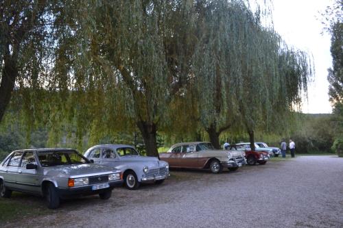 a row of old cars parked under a tree at Auberge Les Sibourgs in Bourdeaux