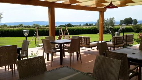 a patio with tables and chairs and a garden at Agriturismo Arlena in Bolsena