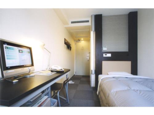 東京にあるR&B Hotel Tokyo Toyocho - Vacation STAY 14255vのベッドと机とパソコンが置かれたホテルの部屋