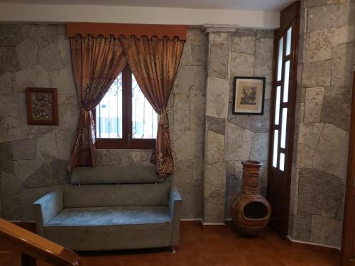 a living room with a couch and a window at Hotel Boutique TEKALI INN in Cuetzalán del Progreso