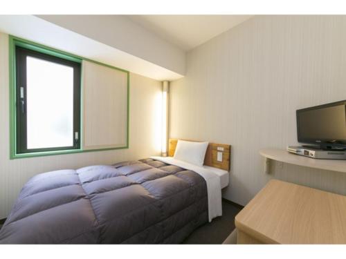 ein Hotelzimmer mit einem Bett und einem Flachbild-TV in der Unterkunft R&B Hotel Shin Yokohama Ekimae - Vacation STAY 14693v in Yokohama