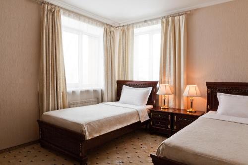 um quarto de hotel com duas camas e uma janela em Richmond Hotel em Ecaterimburgo