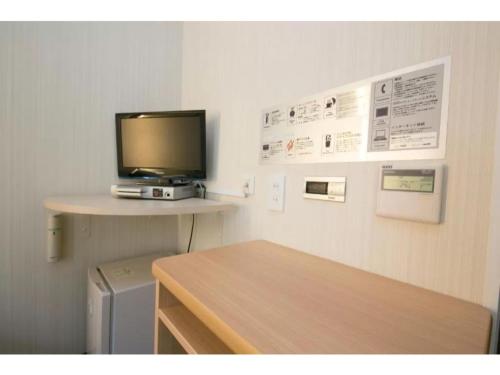 a room with a desk with a television on a wall at R&B Hotel Kumagaya Ekimae - Vacation STAY 14846v in Kumagaya