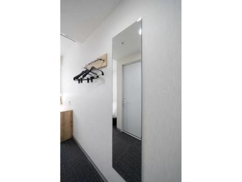 a hallway with a mirror and a white wall at R&B Hotel Nagoya Shinkansenguchi - Vacation STAY 15002v in Nagoya