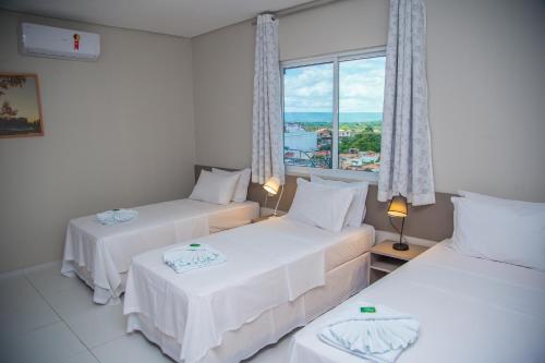 - 2 lits dans une chambre avec fenêtre dans l'établissement Hotel e Pousada Flor do Juá, à Juazeiro do Norte