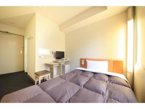 a bedroom with a bed and a desk in it at R&B Hotel Sendai Hirosedori Ekimae - Vacation STAY 15192v in Sendai