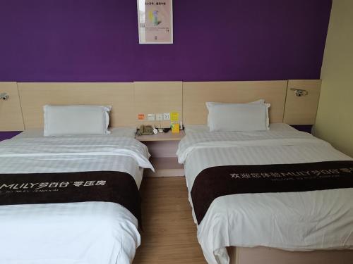 Dos camas en una habitación con morado y blanco. en 7Days Inn Suzhou Xuguan, en Suzhou