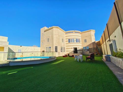 a large yard with green grass and a building at فيلا كارمة in Al Madinah