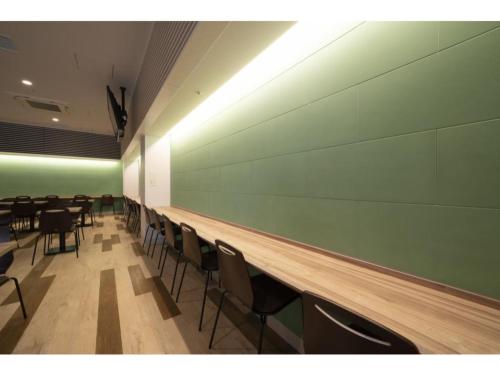 a dining room with chairs and a green wall at R&B Hotel Hakata Ekimae 2 - Vacation STAY 16429v in Fukuoka