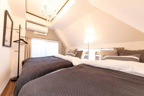 een slaapkamer met 2 bedden op een zolder bij CASA SHINAGAWA UNO - Vacation STAY 18212v in Tokyo