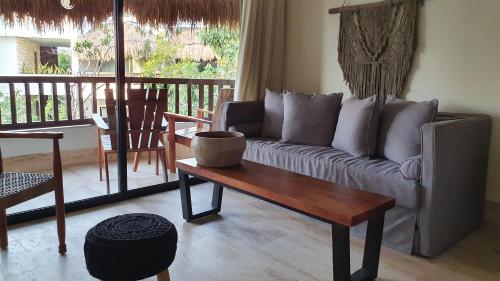 a living room with a couch and a coffee table at Kimpton Aluna Resort Tulum by IHG in Tulum