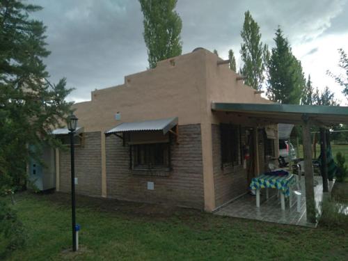 Casa pequeña con mesa y porche en Cabañas Aike en San Rafael