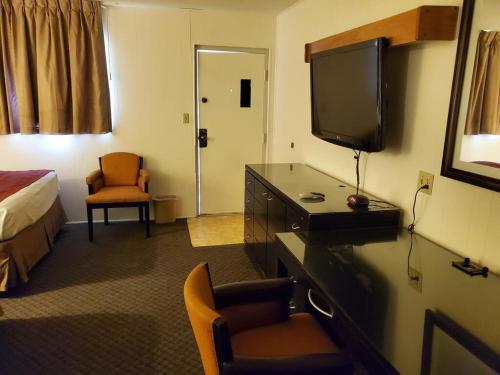 a hotel room with a television and a bed at Sands Motel in Grants