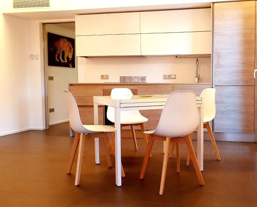 eine Küche mit einem Tisch und weißen Stühlen in der Unterkunft Maison Marquet in Cap d'Ail