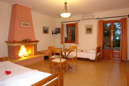 a bedroom with a fireplace and a table and a bed at Xenonas Chrisso in Delfoi