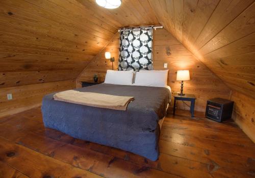 a bedroom with a bed in a wooden cabin at Paradise Hills, Winery Resort & Spa in Blairsville