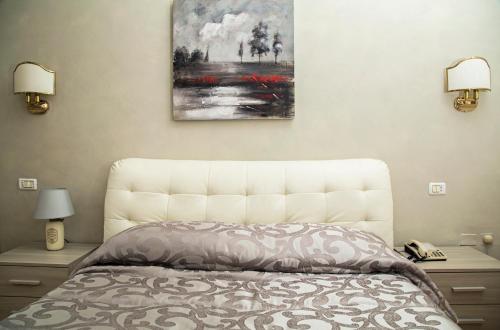 a bedroom with a bed and a painting on the wall at Venafro Palace Hotel in Venafro