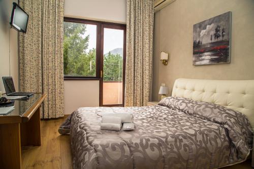 a bedroom with a bed and a desk and a window at Venafro Palace Hotel in Venafro