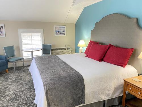 a bedroom with a large bed with red pillows at Harbor House Inn in Grand Haven