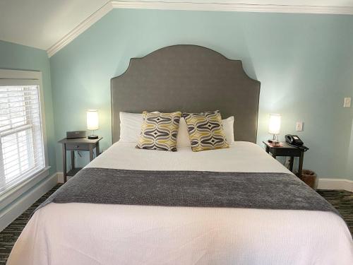a bedroom with a large white bed with two lamps at Harbor House Inn in Grand Haven
