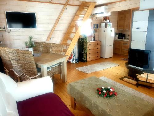 a living room with a table and a kitchen at Juba Holiday House in Võru