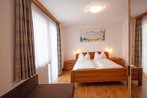a bedroom with a bed with white sheets and pillows at Appartement Bettina Mitterwallner in Altenmarkt im Pongau