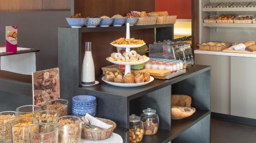 a bakery with bread and other food on a shelf at Crowne Plaza Hotel Brugge, an IHG Hotel in Bruges